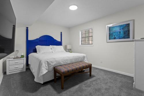 a white bedroom with a blue bed and a bench at Chic & Comfy Stay Close to Everything in Marietta