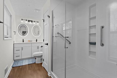 a white bathroom with a shower and a toilet at Chic & Comfy Stay Close to Everything in Marietta