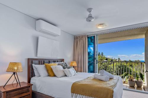 a bedroom with a bed and a large window at Azure Sea Whitsunday Resort in Airlie Beach
