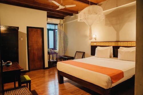 a hotel room with a bed and a desk and a room at Gimanhala Hotel in Dambulla