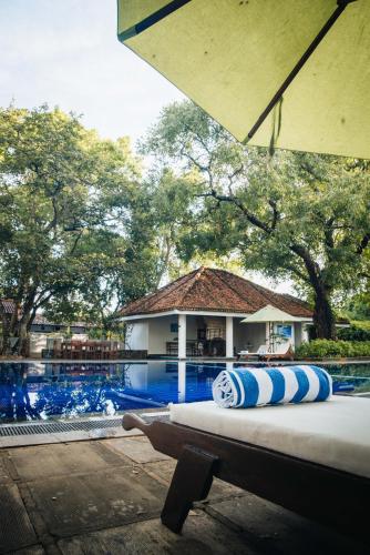 two pillows sitting on a bench next to a swimming pool at Gimanhala Hotel in Dambulla