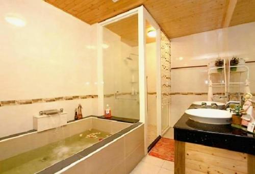 a bathroom with a sink and a bath tub at 水悅雅築民宿 Shuiyue Guest House in Hualien City