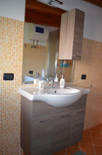 a bathroom with a white sink and a mirror at Terrazza sul golfo degli angeli in Capitana