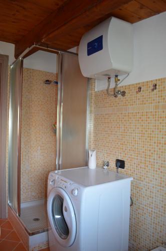 a washing machine in a bathroom with a shower at Terrazza sul golfo degli angeli in Capitana
