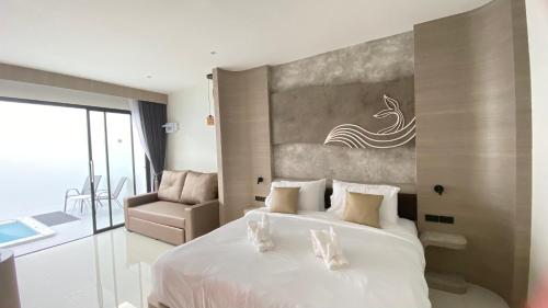 a bedroom with a large white bed and a chair at Mermayda pool villa hatyai -เมอเมดา in Hat Yai