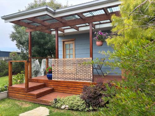 a wooden deck with a pergola on a house at The Blue House in Lake Tyers