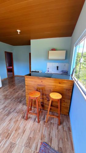 a kitchen with two wooden stools in a room at Paraíso Azul in Ilhéus
