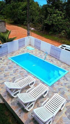 a swimming pool with two lounge chairs and a swimming pool at Paraíso Azul in Ilhéus
