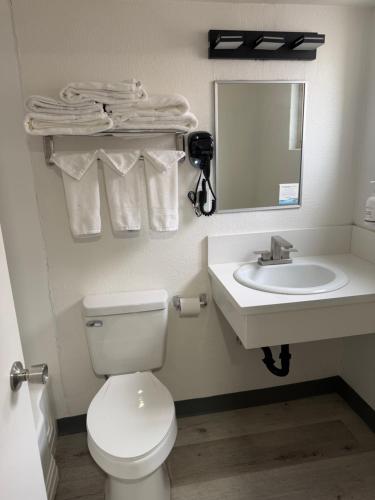 a bathroom with a toilet and a sink and a mirror at DTLV, a Baymont by Wyndham in Las Vegas