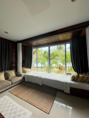 a large bed in a room with a large window at Cookies Salad Resort in Salad Beach