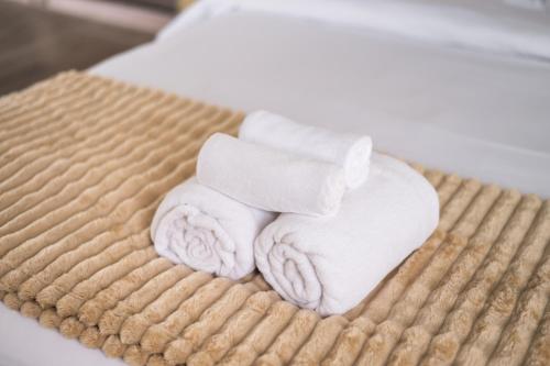 a stack of towels sitting on top of a bed at MIQ Ekkamai1 - 5BR house 65 inch TV in Bangkok