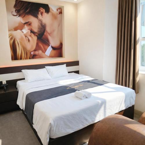 a hotel room with two beds with a picture on the wall at Phương Anh Hotel Dĩ An in Dĩ An