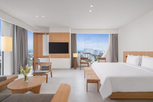 a hotel room with a large bed and a tv at ARTOTEL Leguna Magelang in Magelang