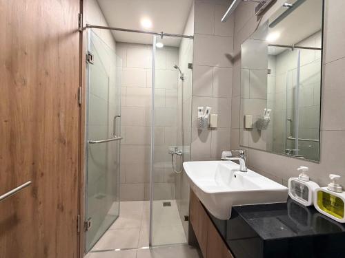 a bathroom with a sink and a glass shower at Homie's The Glory Apartment in Thu Dau Mot