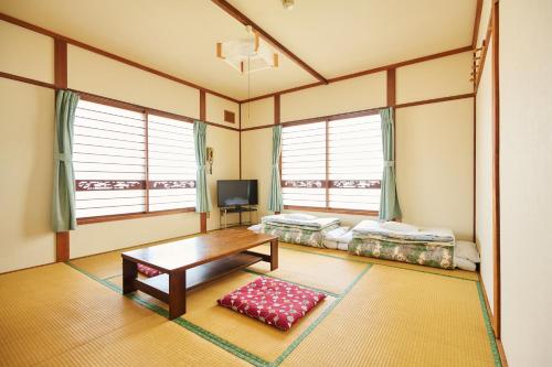a living room with two beds and a table at 旅館おぎた Ryokan Ogita - near Shiraoi Station in Shiraoi