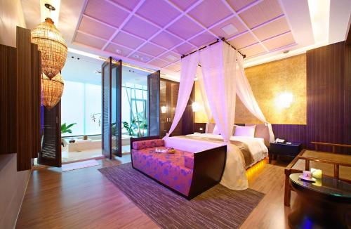 1 dormitorio con 1 cama con techo púrpura en Changhua Laurel Boutique Motel, en Changhua City