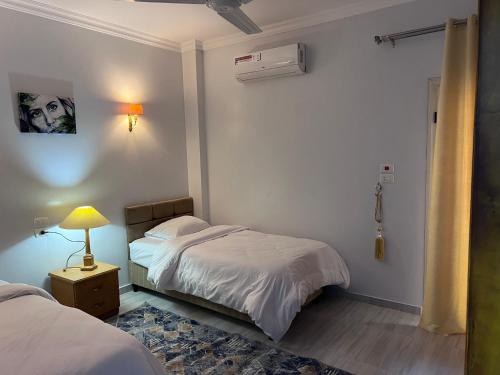 a bedroom with two beds and a lamp on a night stand at Maat apartment in Luxor