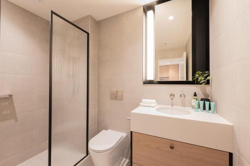 a bathroom with a toilet and a sink and a shower at The Signature Melbourne Modern Nostalgia in Melbourne