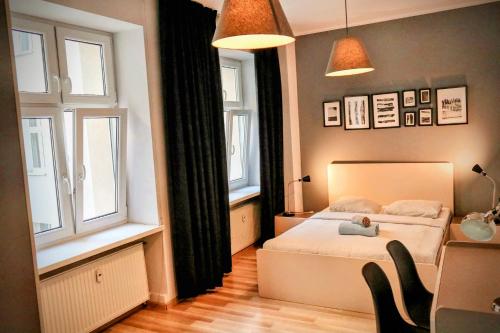 a bedroom with a bed with a teddy bear on it at Armonia Old Town in Poznań