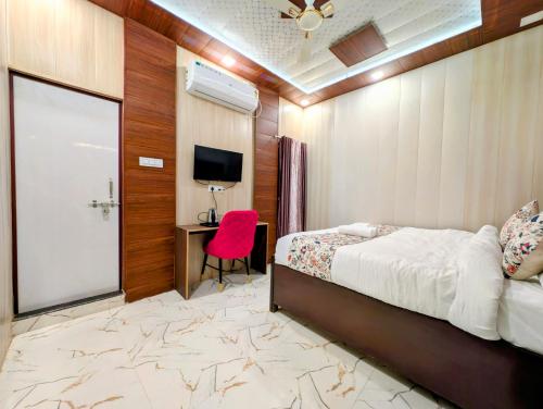 a bedroom with a bed and a desk and a tv at Ganga Yamuna View in Prayagraj