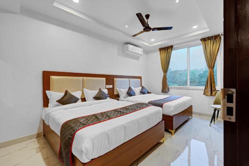 a bedroom with two beds and a window at Hill Hara in Tirupati