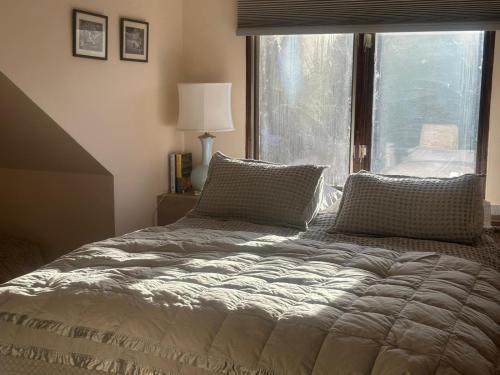 a bed in a bedroom with a large window at Modern barn by the creek in Evergreen
