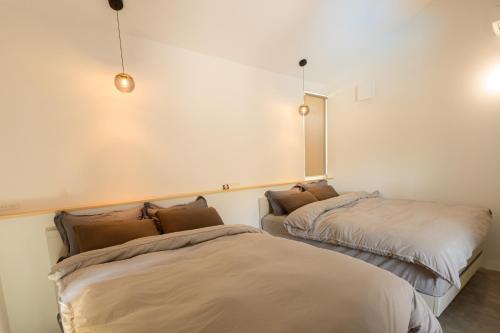 ein Zimmer mit zwei Betten und einem Spiegel an der Wand in der Unterkunft HiTOSE in Takashima