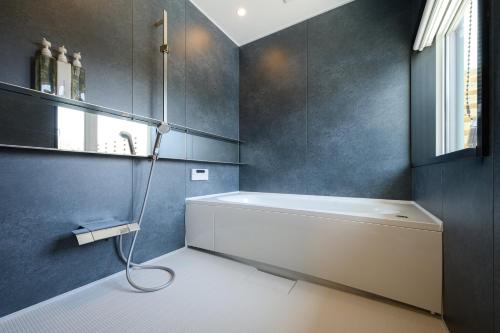 ein Badezimmer mit Badewanne und Fenster in der Unterkunft HiTOSE in Takashima