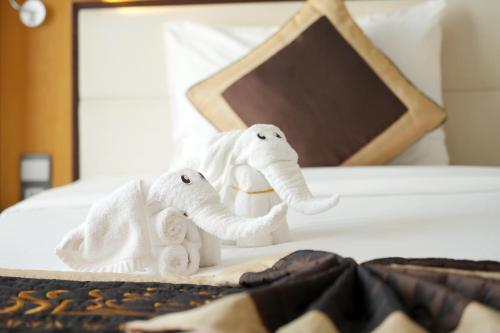 two towel animals are sitting on a bed at Dragon Sea Sam Son Hotel in Sầm Sơn