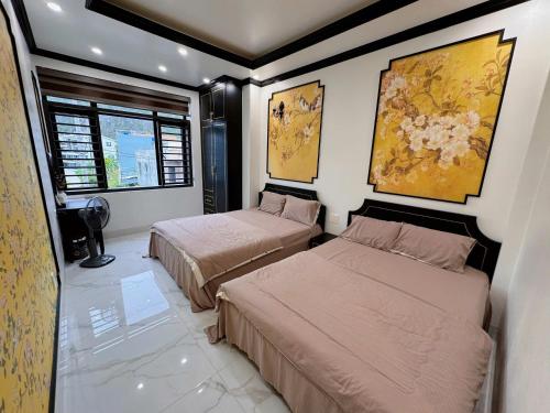 two beds in a room with two windows at Cat Ba Cam's Villa in Cat Ba