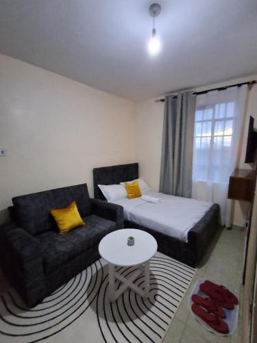 a room with a couch and a bed and a table at Machakos Town studios in Machakos
