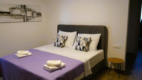 een slaapkamer met een groot bed met paarse lakens en kussens bij Villa Luminosa by Villas Guide in Šmrika