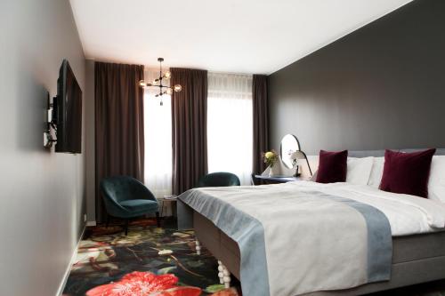 a hotel room with a bed and a chair at Elite Palace Hotel & Spa in Stockholm