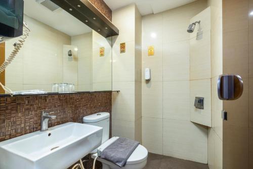 ein Badezimmer mit Waschbecken und Toilette in der Unterkunft Favor Hotel Makassar City Center By LIFE in Makassar