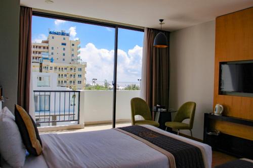 a hotel room with a bed and a large window at Dragon Sea Sam Son Hotel in Sầm Sơn