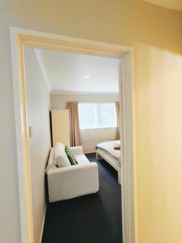 a small room with a bed and a mirror at Bayview Holiday Flat in Auckland