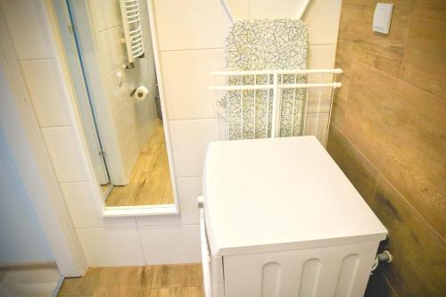 a white toilet in a bathroom with a mirror at Armonia Old Town in Poznań