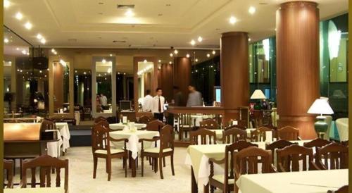 un ristorante con tavoli e sedie e persone sullo sfondo di Sri U-Thong Grand Hotel a Suphanburi