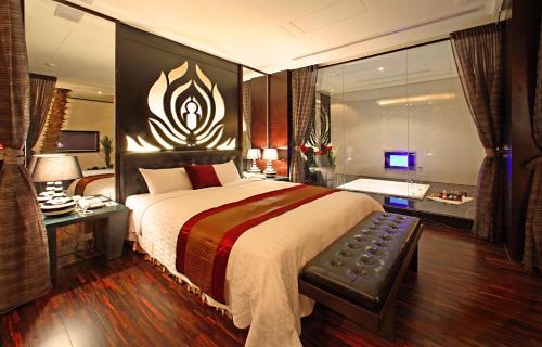 a bedroom with a large bed and a bathroom at Changhua Laurel Boutique Motel in Changhua City
