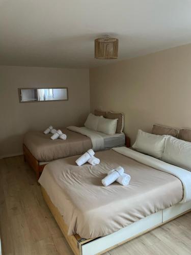 two beds in a room with white towels on them at Villa Mandalika in Noisy-le-Grand