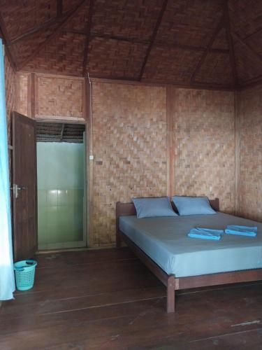 a bedroom with a bed in a brick wall at Togean Pulotiga Resort in Popolii