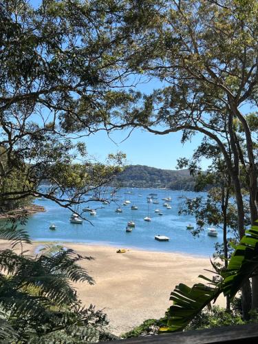 a view of a beach with boats in the water at Sydney Northern Beaches Pitterwater Waterfront Holiday House Avalon Beach - Clareville in Clareville