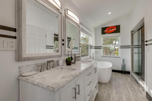 a white bathroom with a sink and a mirror at 3-Acre Retreat, 3 Mi to Dtwn Jensen! Upscale Home in Jensen Beach
