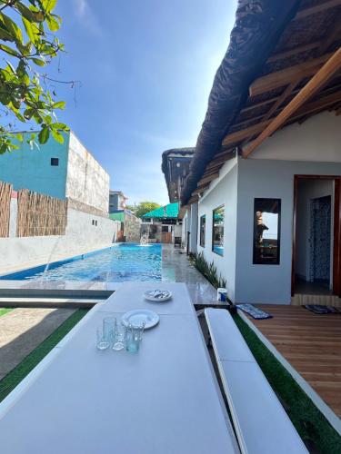 een witte tafel met glazen erop naast een zwembad bij 50pax private Beachfront Villa with pool in Nasugbu
