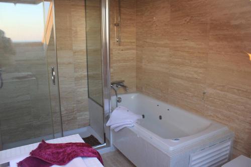 a bathroom with a shower and a bath tub at COMPEJO RAEIROS O GROVE, S Vicente do Mar in Balea