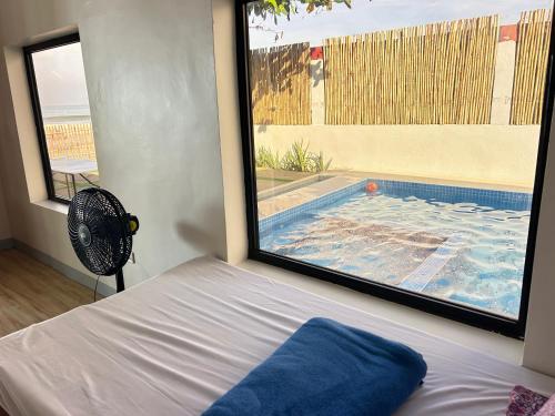 een slaapkamer met uitzicht op een zwembad bij 50pax private Beachfront Villa with pool in Nasugbu