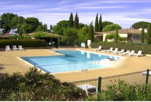 une grande piscine avec des chaises et une maison dans l'établissement Le Mazet 40, à Saint-Rémy-de-Provence