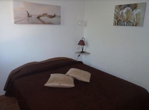 Un dormitorio con una cama grande con dos cuadros en la pared. en Le Mazet 40, en Saint-Rémy-de-Provence