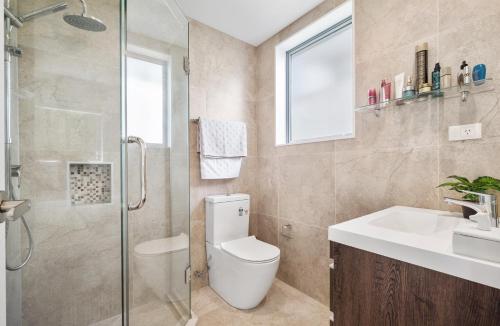 a bathroom with a toilet and a sink and a shower at Blue Horizon in Auckland