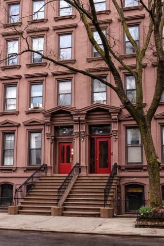 a building with red doors and stairs in front at New York City Guesthouse 3 in New York